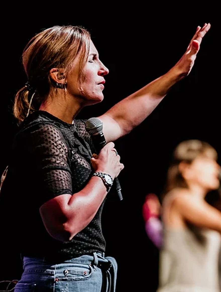 Nexus Church: a worship leader on stage with a hand raised